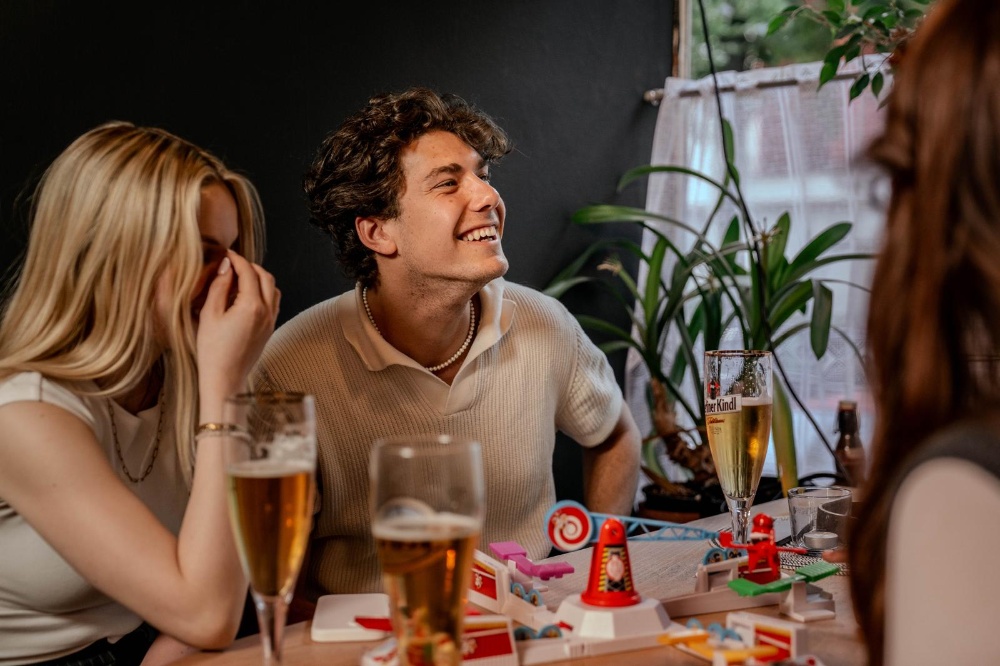 Lachende Gäste am Tisch beim Tischspiel
